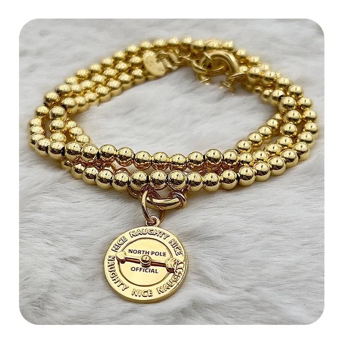 Gold beaded bracelet with a pendant on a marble surface - 2